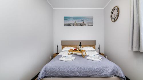 ステグナにあるSTEGNA PARK II blisko plaży Apartamenty Piamolaのベッドルーム1室(ベッド1台、壁掛け時計付)