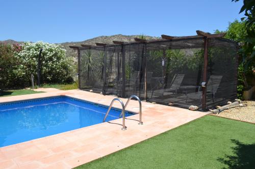 a pool with a gazebo next to a house at Mas Solana in Huércal-Overa