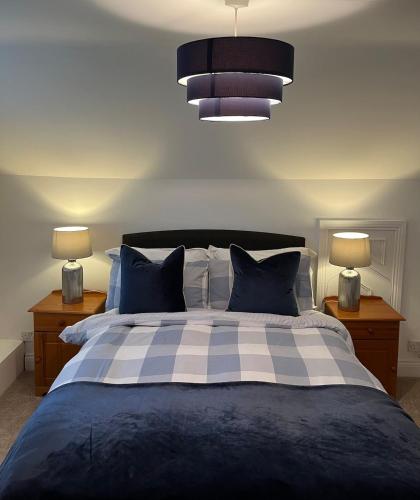 a bedroom with a blue and white bed with two lamps at 1800's Cosy Cottage in Dungarvan in Balnacart