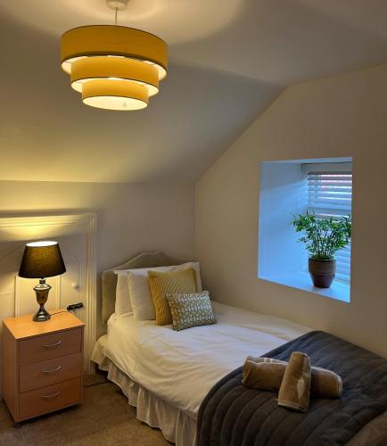 a bedroom with a bed and a lamp and a window at 1800's Cosy Cottage in Dungarvan in Balnacart