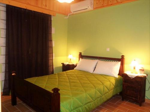 a bedroom with a bed with two night stands and two lamps at Menina Farm Kalamata Countryside in Perivolákia