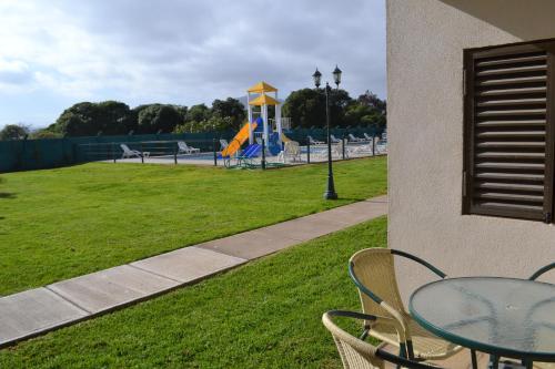 a table and chairs in a park with a playground at Cabañas Las Añañucas V in La Serena