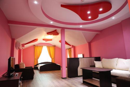 a living room with pink walls and a couch at Meatsa Hotel in Kŭrdzhali