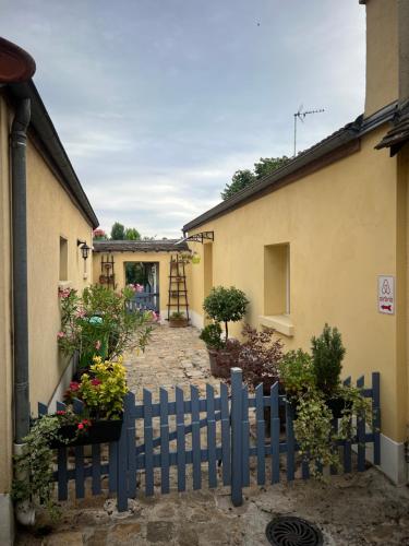 a blue fence in front of a house with flowers at Petite maison indépendante à 20min de Paris in Bonneuil-sur-Marne