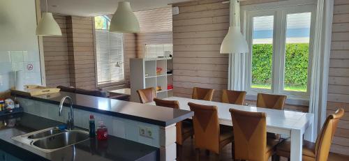 a kitchen with a sink and a table and chairs at The Blue House - Luxurious Waterfront Villa Zeewolde in Zeewolde