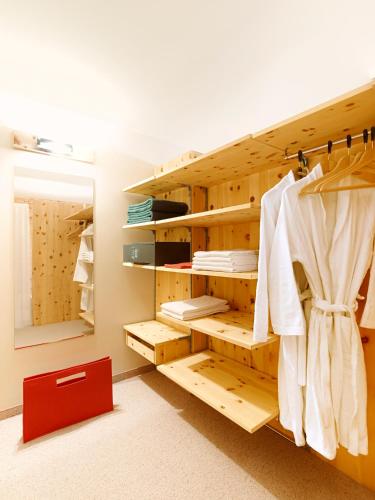 a closet with wooden shelves and a red drawer at Arosea Life Balance Hotel in Santa Valburga St. Walburg