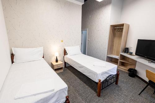 a room with two beds and a tv at Agape Villa Apartments in Novi Sad