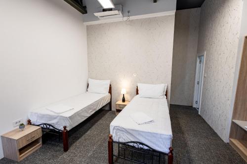 two beds in a room with two tables and a bed sidx sidx sidx at Agape Villa Apartments in Novi Sad