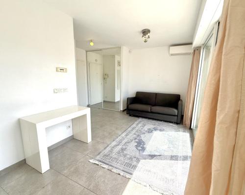un salon avec un canapé et une table dans l'établissement Studio Terrasse 3ème étage, climatisation coeur de Nice, à Nice