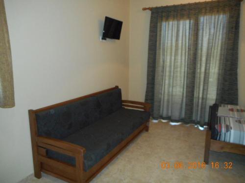 a living room with a couch and a tv at Dimitra's Apartments in Olympiaki Akti