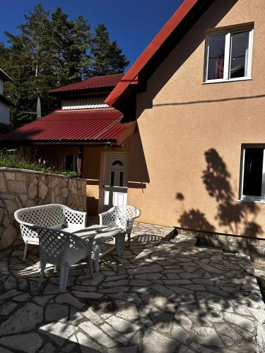 a patio with a table and chairs in front of a building at Guest House Dzakovic Stana in Žabljak