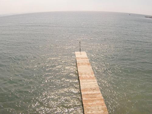 a wooden pier in the middle of the water at Olive Press Hotel in Mithymna