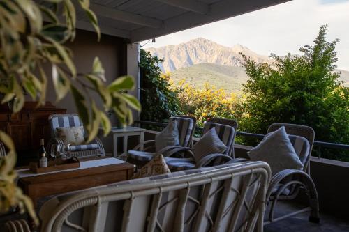 a row of chairs on a balcony with a mountain at Leipzig Country House & Winery in Nuy