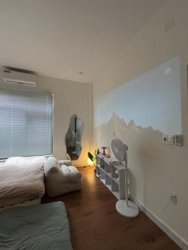 una camera da letto con un letto e un murale di montagna sul muro di June Homestay a Hue