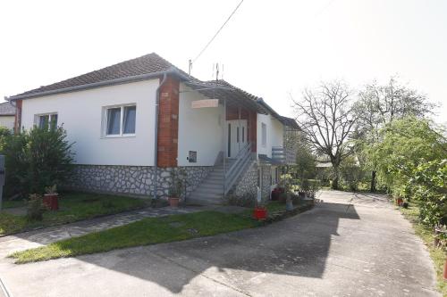 a white house with a staircase in a driveway at Total Relax Apartmanház in Bogács