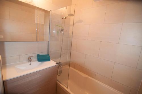 une salle de bain avec une douche, un lavabo et une baignoire dans l'établissement Duinenblik 3, à Nieuport