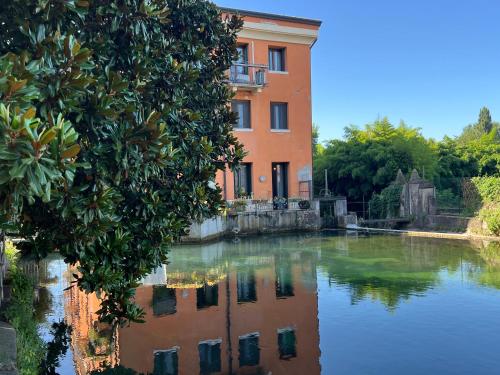 a building next to a body of water at La casa ai Laghetti in Montorio Veronese
