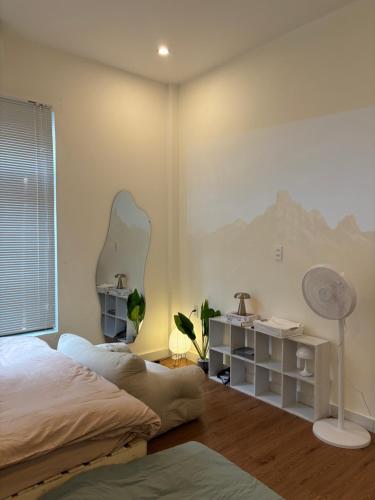 una camera da letto con un letto e uno specchio sul muro di June Homestay a Hue