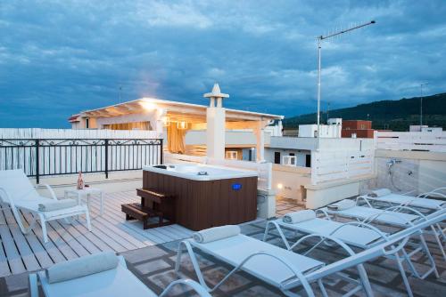 a rooftop deck with chairs and a hot tub at Antica Via Roma B&B E RELAX in Montalbano