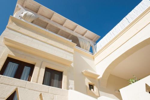 a building with a balcony on top of it at Antica Via Roma B&B E RELAX in Montalbano
