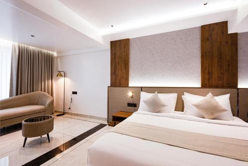 a hotel room with a bed and a couch at Royal Plaza Inn by RAK Rooms, Calicut in Kozhikode