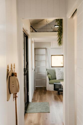 a hallway with a living room with a couch at The Ranch Cabarita Beach - Tiny Home in Clothiers Creek