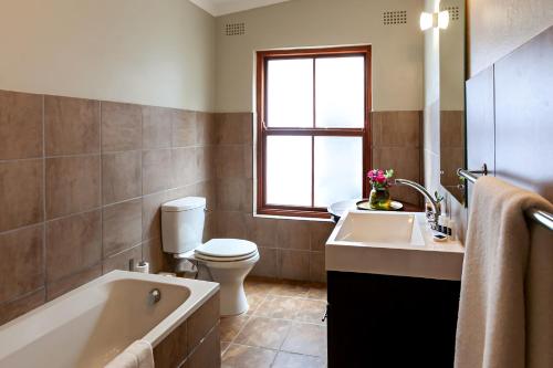 a bathroom with a tub and a toilet and a sink at Leipzig Country House & Winery in Nuy