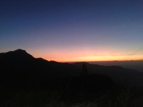 a silhouette of a mountain with the sunset in the background at Bel View Guest House in Haputale