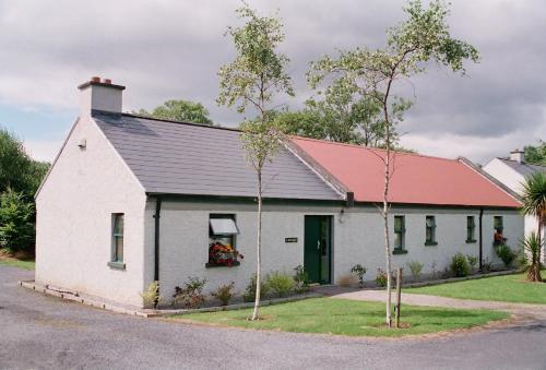 a white building with a red roof at Lough Lannagh Self Catering Cottages in Castlebar