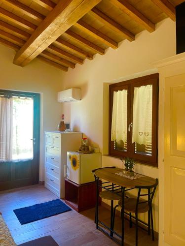 a kitchen with a table and a refrigerator at Affittacamere LA TENUTA in Spello