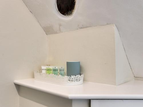 a white shelf with a candle on top of it at Pass the Keys Newly renovated flat Sevenoaks High Street in Sevenoaks