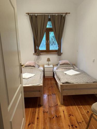 two beds in a room with a window at U Poli w Gaju in Zbiczno