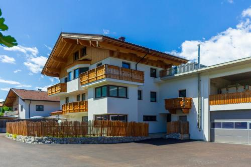 a white building with wooden balconies on it at Ferienwohnung am Bauernhof, Korbingerhof in Rinn