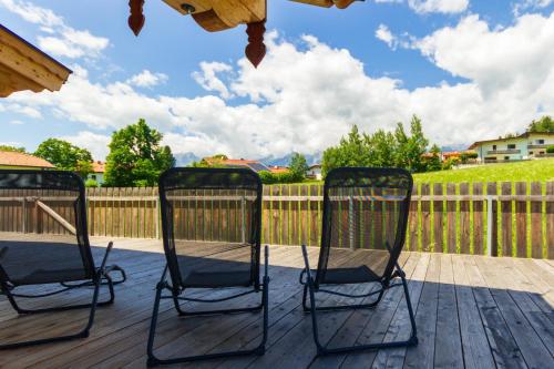 two chairs sitting on a deck with a fence at Ferienwohnung am Bauernhof, Korbingerhof in Rinn