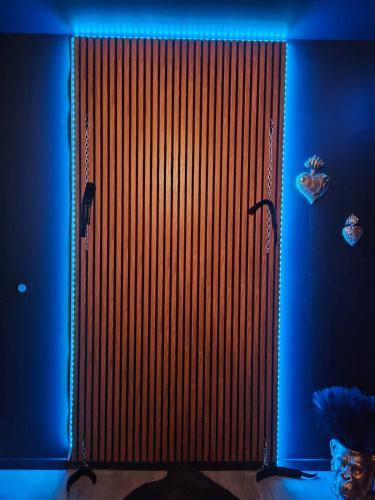 Saint-Vincent-de-PaulにあるMaison M Intime Roomの青い光が灯る部屋にある大きな木製のドア
