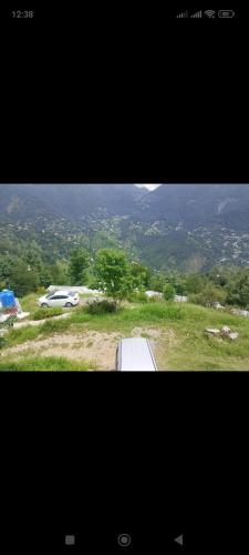 a picture of a van parked in a field at WanderNest BirmiGali in Abbottābād