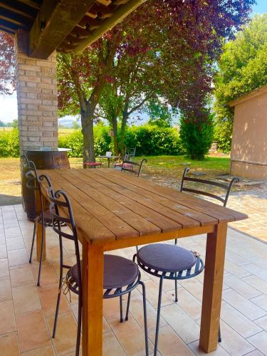 a wooden table and chairs on a patio at Affittacamere LA TENUTA in Spello