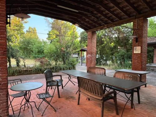 a patio with tables and chairs and a table and chairs at La casa ai Laghetti in Montorio Veronese