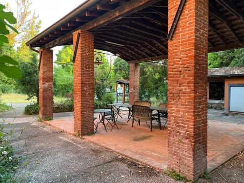 a brick pavilion with a table and chairs on a patio at La casa ai Laghetti in Montorio Veronese