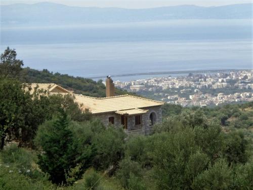 a house on a hill with a city in the background at Menina Farm Kalamata Countryside in Perivolákia