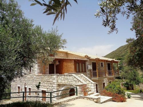 a stone house with a balcony in a yard at Menina Farm Kalamata Countryside in Perivolákia