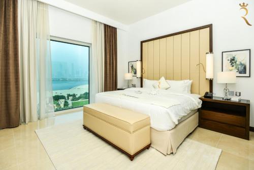 a bedroom with a large bed and a large window at Azure Crest 2BR - Ocean View Apartment Near Marina Mall in Abu Dhabi