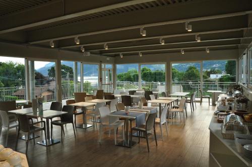 a restaurant with tables and chairs and windows at Hotel Vischi in Domaso
