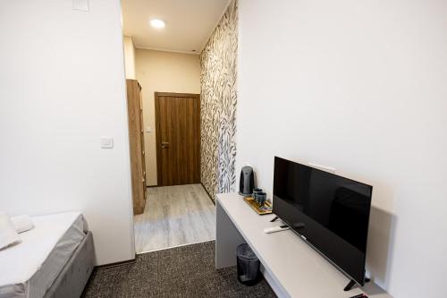 a living room with a flat screen tv on a table at Agape Villa Apartments in Novi Sad