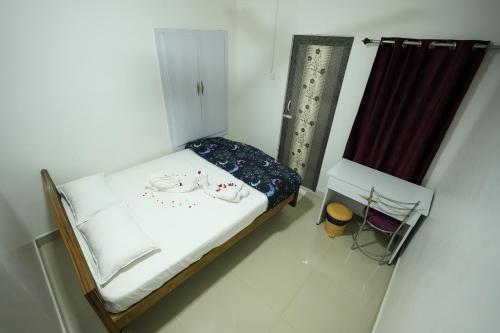 a small bedroom with a bed and a curtain at ABM Homestay in Thanjāvūr