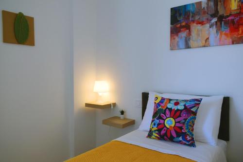 a bedroom with a bed with a colorful pillow at Granatelli Holiday Home in Altavilla Milicia