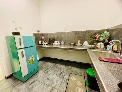 a kitchen with a blue refrigerator and a sink at Nimal's House in Dickwella