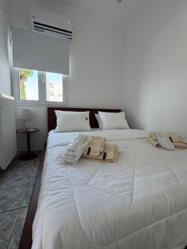 a white bedroom with two beds with towels on them at Agia Anna Horizon in Kranidi