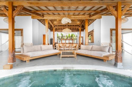 une piscine intérieure avec deux canapés et une table dans l'établissement Villas Tirta Complex - Bingin, à Uluwatu