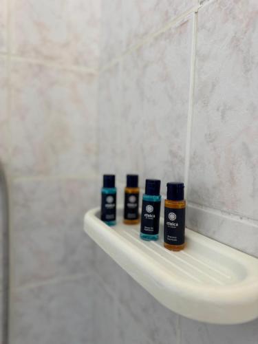 a bathroom sink with three bottles on a shelf at Agia Anna Horizon in Kranidi